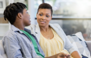 A photo of a teen and an adult speaking