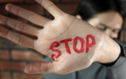 An image of a woman holding her hand out with the word "STOP" written on it