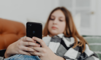 A photo of a young person using a smartphone