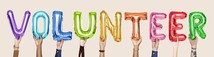 The word volunteer spelt out in different coloured balloons