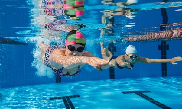 Female swimmer swimming underwater in leisure centre pool
