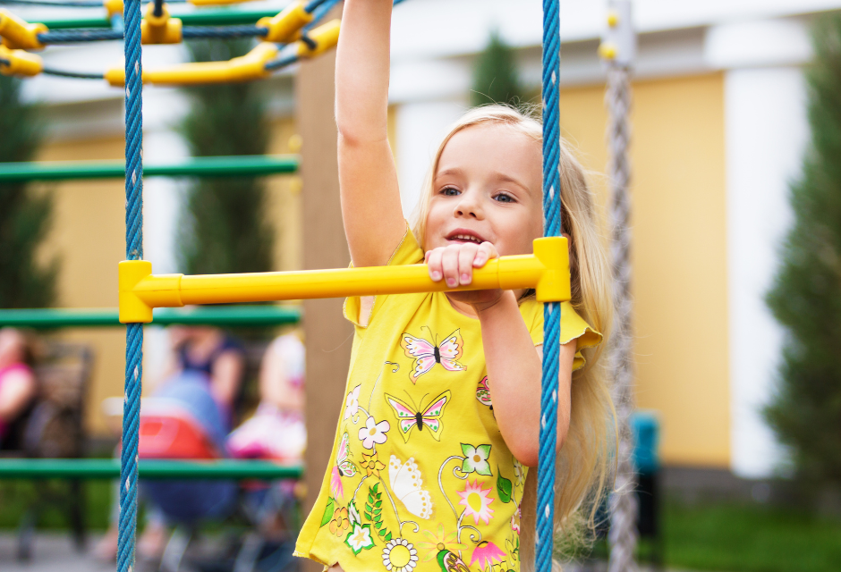 A little girl climbs a ladder in a playpark