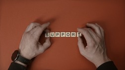 The word 'support' written in scrabble tiles.