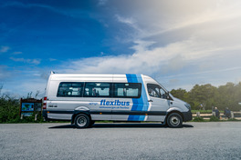 A minibus branded with the FlexiBus logo