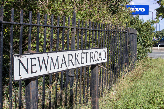 Newmarket Road street sign against black railings