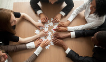 Diverse team people assembling jigsaw puzzle