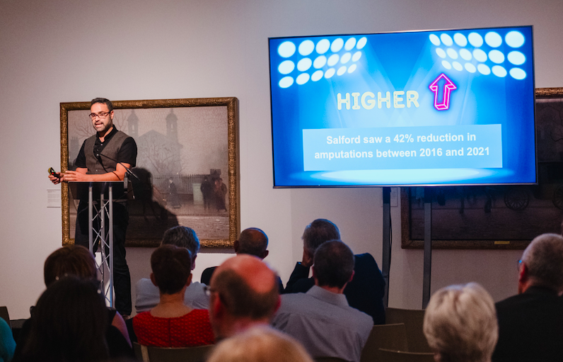 Man speaking to an audience from a lectern