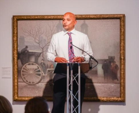 Person stood at lectern talking to audience 