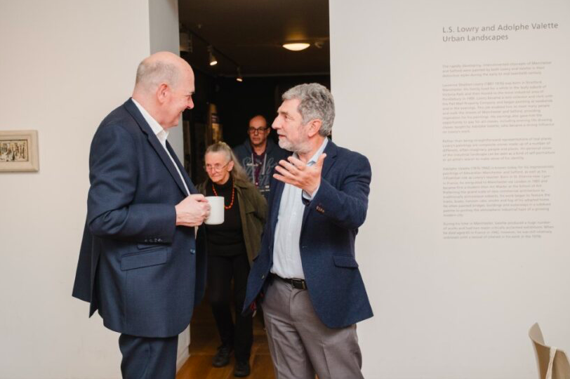 Two men talking in a room 