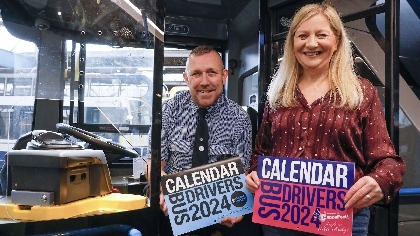 Two bus drivers posing with Bus Driver Calendar 2024