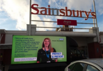 Picture of Dr Jennifer Hoyle and a quote on the side of a van next to a supermarket