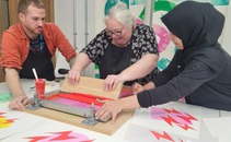 Three people screenprinting