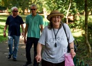 three older people walking in the sun wearing sunhats