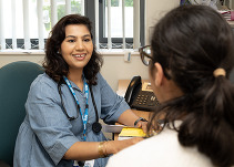 Clinical pharmacist talking to a patient at a desk