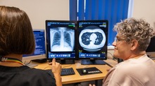 picture of a xray scan with a nurse pointing at it next to the MP smiling