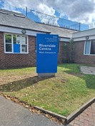 blue and white entrance sign in front of building