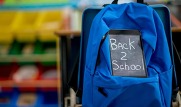 chalkboard saying back to school with blue rucksack