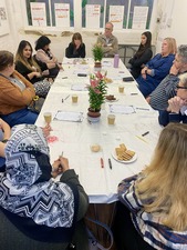 Group of people sat round a table talking 