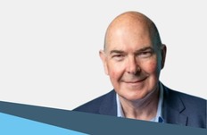 head and shoulder of a male smiling at camera wearing a suit