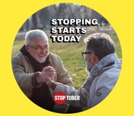 two men shaking hands and smiling outside in nature
