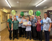 staff holding balloons and certificate