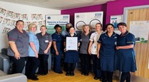 group of healthcare holding a certificate on a ward