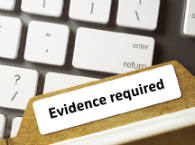 Laptop keyboard with file marked 'Evidence required' lying across it