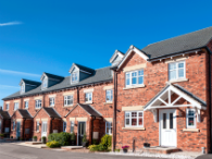 Terrace of brick-built homes with sloping roof and dormer windows