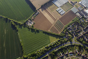 Aerial view of landscape of fields, roads, homes and businesses.