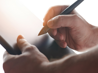 Hands holding a stylus and a screen in preparation for applying an electronic signature.