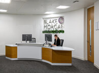 Receptionist sits at desk in Blake Morgan LLP's reception area