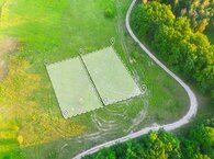 Aerial shot of a green field with two plots marked out.