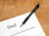 A pen lying across the corner of a document headed 'Deed'.