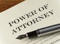 Power of attorney document with silver fountain pen lying across it.