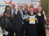 Seven Local Land Charges Programme members hold aloft the award and raise their arms to celebrate winning.