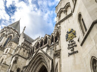 Looking upwards at the entrance and upper floors of the Royal Courts of Justice in central London.