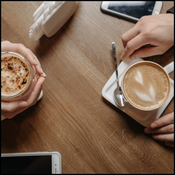 two coffees on a table at a cafe