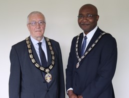 Cllr Graham, left, and Cllr Eni, right, pose with Mayoral chains.