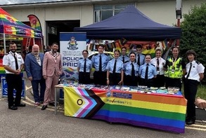 Emergency services and council personnel standing together in one of the pride event stalls.