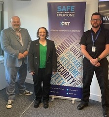 Safety talk speakers standing in front of a security advice sign.