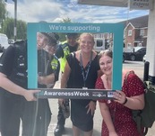 Officers from Hertsmere Police and Hertsmere Borough Council taking a photo with the ASB Awareness Week selfie board.