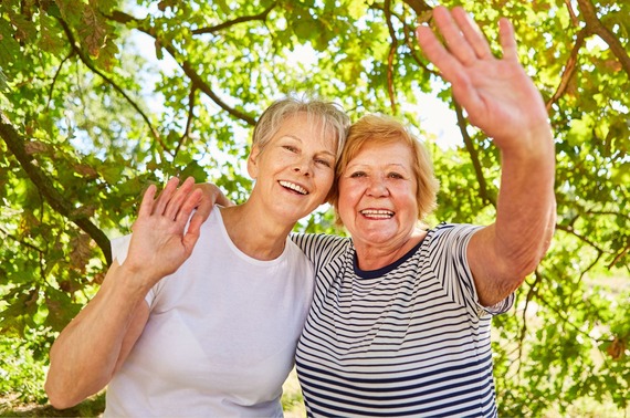 two elderly women waving