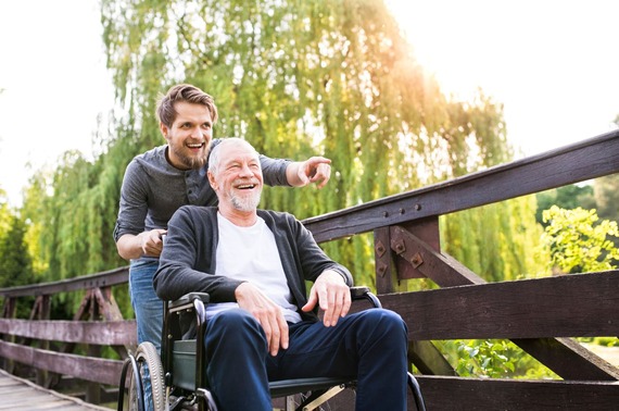 A man pushing an elderly gentleman in a wheelchair