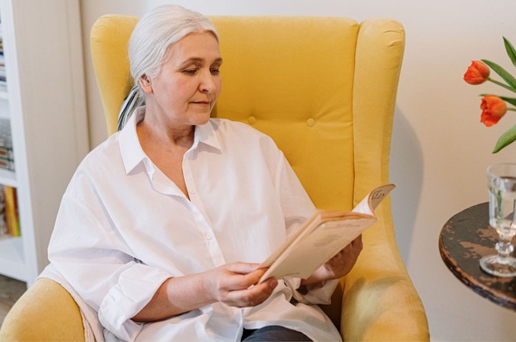 An elderly lady sat reading a book