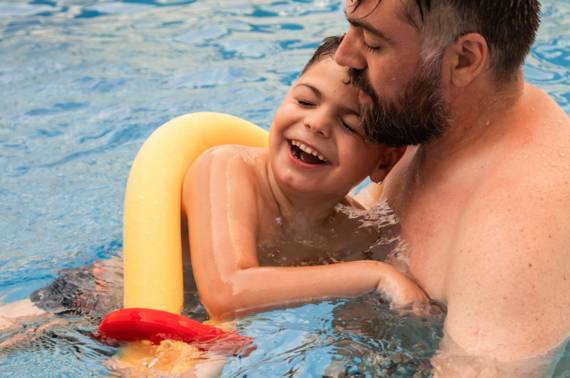 A disabled boy swimming with his father