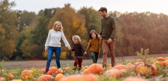 a family walking through a pumpkin patch together