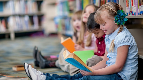 children sat reading together in a library