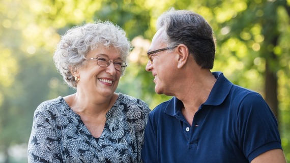 an elderly couple smiling at eachother