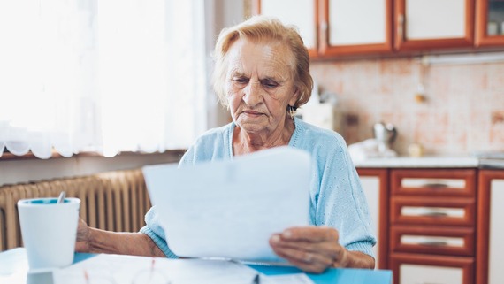 an elderly woman reading her bills