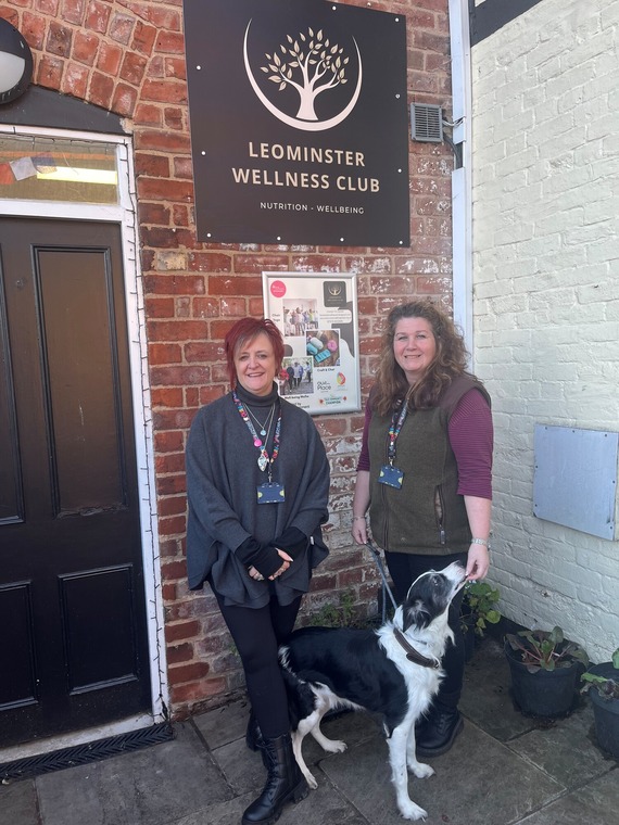 the hub owners stood in front of the hub with their dog